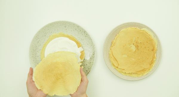 Extender los panqueques y cubrir cada uno de ellos con parte de la masa cremosa. Colocarlos uno encima del otro. Servir la torta de panqueques adornada con el resto de la masa cremosa y las frutas frescas.