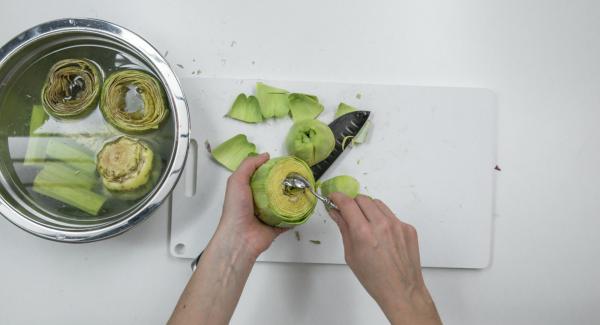 Quitar la mitad superior de las alcachofas, quitar las hojas duras del exterior y quitar el centro. Poner las alcachofas y los tallos en remojo en el agua con limón.