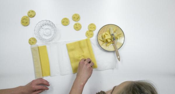 Cubrir con cuidado con la otra mitad de la masa, presionar bien alrededor del relleno y cortar los raviolis.