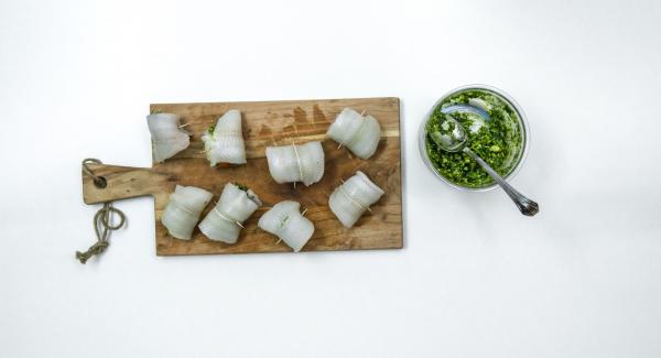 Untar un poco de pesto en los filetes de pescado y enrollar con un tomate cherry cada uno, fijándolos con palillos de dientes. Colocar los rollitos en la Softiera  24 cm.