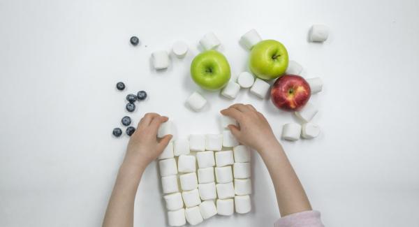 Si desea hacer que la cara graciosa de la rana sea una decoración, necesitará dos manzanas verdes, una manzana roja para la boca y dos malvaviscos y arándanos para los ojos.