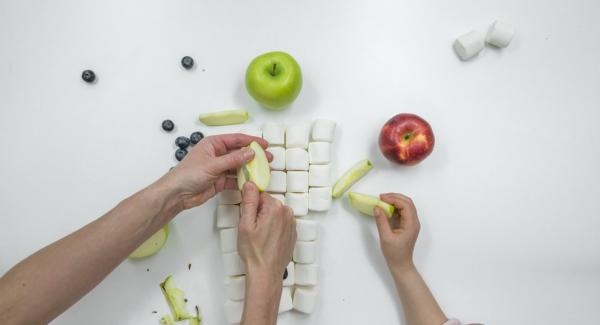 Si desea hacer que la cara graciosa de la rana sea una decoración, necesitará dos manzanas verdes, una manzana roja para la boca y dos malvaviscos y arándanos para los ojos.