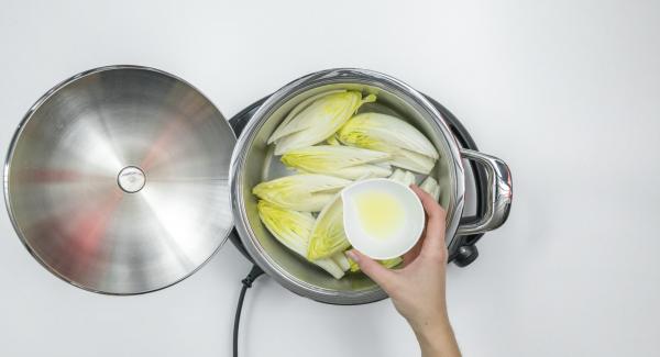 Limpiar la endivia, cortarla por la mitad a lo largo y retirar la cuña amarga del centro. Verterla húmeda en la olla y rociar con jugo de limón.