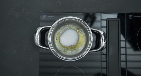 Colocar una olla pequeña con una cucharada de azúcar en el fuego a temperatura máxima. Tan pronto como el azúcar empiece a derretirse y comience a oscurecerse, bajar el fuego y añadir poco a poco 60 g. de azúcar hasta que esté caramelizado.