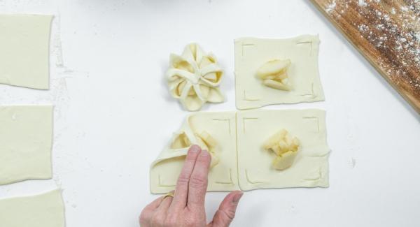 Poner unos dados de pera en el centro y doblar los bordes de la masa sobre las peras como una flor y presionarlas un poco (ver foto).