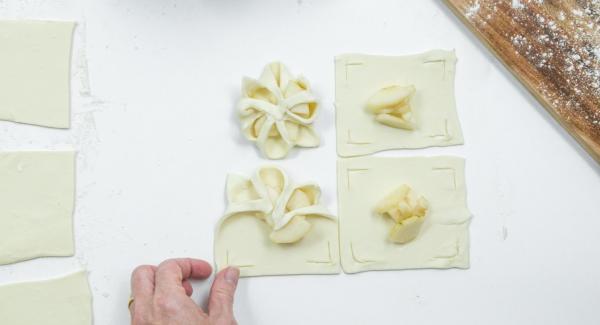 Poner unos dados de pera en el centro y doblar los bordes de la masa sobre las peras como una flor y presionarlas un poco (ver foto).