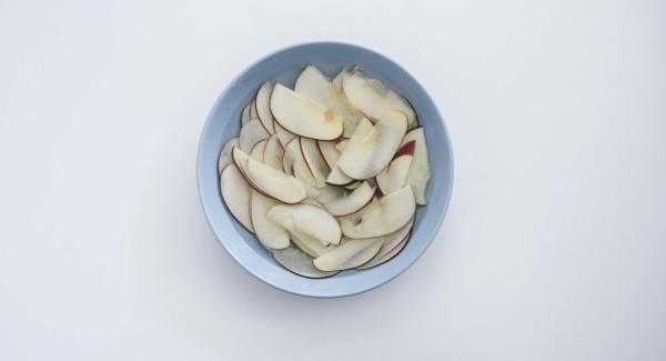 Partir la manzana por la mitad, quitar el corazón y partir en rodajas finas. Cubrir con agua.