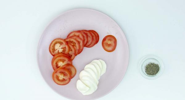 Con las pizzetas todavía calientes, añadir unas rodajas de tomate natural, unos trozos de mozzarella y orégano por encima. Servir.