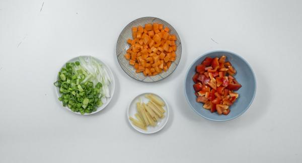 Limpiar y cortar las zanahorias y los pimientos en daditos pequeños. Cortar la parte blanca de la cebolleta en tiras de unos 4 cm de largo. Cortar la parte verde en anillos finos. Cortar el parmesano en tiras.