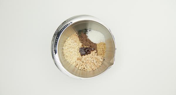 Mezclar el aceite de coco con miel y canela, añadir a la mezcla de muesli y mezclar bien. Cortar un círculo de papel de hornear con la tapa de 24 cm.