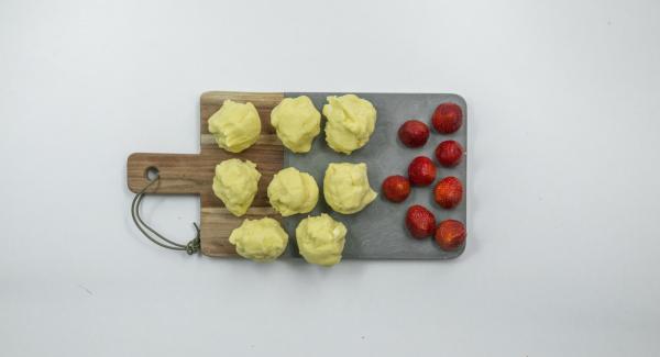 Dividir la masa en ocho porciones, formar tortitas y envolver cada fresa con ellas hasta obtener una bola.