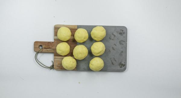 Dividir la masa en ocho porciones, formar tortitas y envolver cada fresa con ellas hasta obtener una bola.