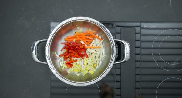 Cuando el Avisador (Audiotherm) emita un pitido al llegar a la ventana de “chuleta”, bajar la temperatura y freir la mezcla de jenjibre y cebolla removiendo. Añadir las verduras y freír sin dejar de remover.