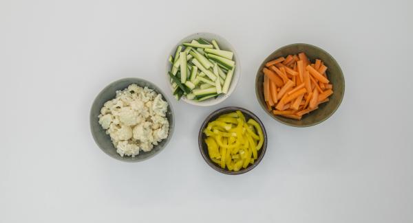 Pelar las zanahorias, limpiar los calabacines y los pimientos y cortar todo en tiras. Limpiar la coliflor y dividirla en pequeños ramilletes.