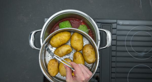 Añadir la salsa de tomate. Colocar las patatas en la Softiera,  introducir en la olla y tapar con la Tapa Rápida (Secuquick Softline). Ajustar el fuego a temperatura baja cocinar en el símbolo de "soft "durante aproximadamente 10 minutos con el Avisador (Audiotherm).