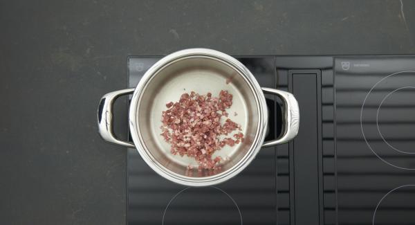 Cuando el Avisador emita un pitido al llegar a la ventana de “chuleta”, bajar la temperatura, añadir los dados de bacon y freír. Incorporar la cebolla y freír.