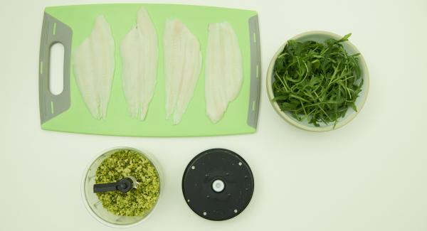 Colocar los filetes de pescado en una tabla. Introducir el parmesano y los pistachos en Quick Cut y picar finamente. Añadir el la rúcula y picar. Agregar el aceite de oliva, sazonar con sal, pimienta y mezclar.