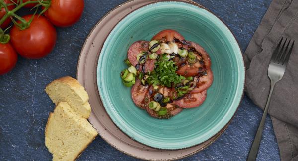 Picar las hojas de albahaca, servir la ensalada con la salsa y las hojas de albahaca.