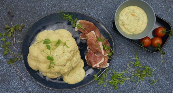 Colocar la coliflor en una fuente y añadir la salsa. Servir con jamón y cress al gusto.